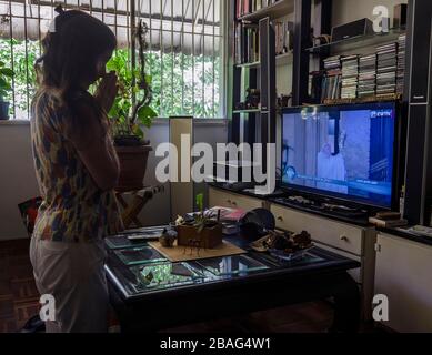 Caracas, Miranda, Venezuela. März 2020. Eine Frau betet von zu Hause aus und hört auf den Segen des Heiligen Vaters. Papst Franziskus segnet die Welt und segnet Urbi et Orbi von der Kathedrale und dem Petersplatz in der Vatikanstadt in einer historischen Handlung, die auf die weltweite Coronavirus-Pandemie zurückzuführen ist. Credit: Jimmy Villalta/ZUMA Wire/Alamy Live News Stockfoto