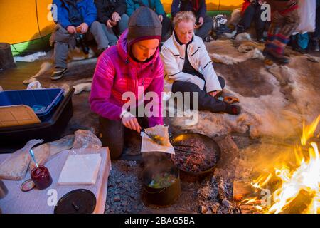 Ein Mittagessen mit Rentierfleisch wird für Touristen in einem Lavvu vorbereitet, einem Zelt, das eine temporäre Wohnung ist, die von den samischen Leuten hier am Sam genutzt wird Stockfoto