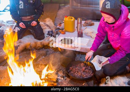 Ein Mittagessen mit Rentierfleisch wird für Touristen in einem Lavvu vorbereitet, einem Zelt, das eine temporäre Wohnung ist, die von den samischen Leuten hier am Sam genutzt wird Stockfoto