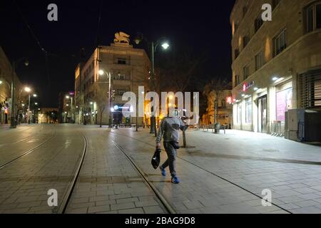 Einsame Fußgängerin, die Gesichtsmaske trägt, spaziert bei Ausbruch der Coronavirus-Krankheit (COVID-19) in Israel entlang der Jaffa-Straße die längste und wichtigste Straße in Jerusalem Stockfoto