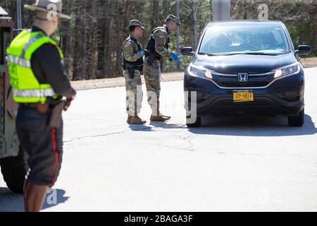 Richmond, Rhode Island, USA. März 2020. Richmond, Vereinigte Staaten. März 2020. Ein Mitglied der Rhode Island Army National Guard spricht am Freitag, 27. März 2020 mit einem Fahrer mit New Yorker Kennzeichen in einem Rastplatz in Richmond, Rhode Island. Die Staatspolizei und die Nationalgarde der Rhode Island Army tragen dazu bei, eine obligatorische 14-tägige Quarantäne für alle Besucher aus dem Staat New York im Rahmen der COVID-19-Antwort von Rhode Island durchzusetzen. Die Gouverneurin von Rhode Island, Gina Raimondo, kündigte die neuen Quarantänebeschränkungen für New Yorker während ihrer Pressekonferenz am Donnerstag an. Foto von Matthew Healey/UPI Stockfoto