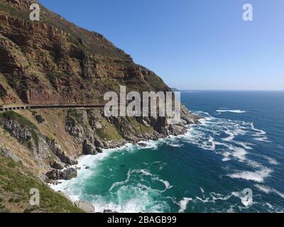 Luftbild des Chapman's Peak mit Wellen, die gegen Felsen und Tunnel abstürzen Stockfoto