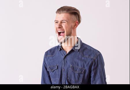 Porträt des aggressiven bärtigen Flusspferdes, isoliert auf weißem Hintergrund. Junger stilvoller Mann schreit laut und drückt seine negative Emotion aus Stockfoto