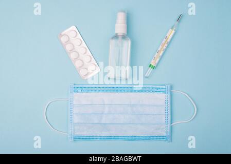 Konzept für Hygiene und Selbstvermeidung. Oben über dem Kopf Nahaufnahme Foto der Flasche mit Flüssigthermometer Tabletten und medizinischer Maske isoliert über b Stockfoto