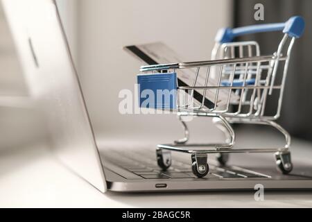 Ein Mini-Trolley aus einem Supermarkt steht auf einer Laptop-Tastatur. Das Konzept des Online-Einkaufs während der Quarantäne Stockfoto