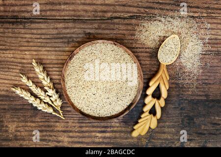 Masernkornnahrung in einer Schüssel & Liebeslöffel mit Weizenmantel. Hoher Gehalt an Ballaststoffen, Antioxidantien, Kalzium, Proteinen und weniger Cholesterin. Stockfoto