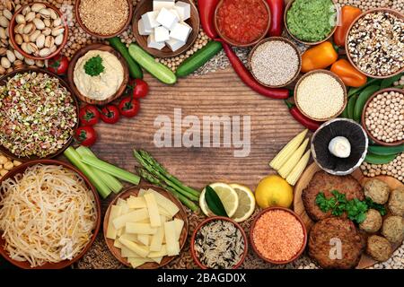 Gesundheitskost für Veganer Hintergrund Grenze mit Falafel & Burgern, Obst, Gemüse, Getreide, Tofu, Pasta, Samen, Nüssen, Dips & Hülsenfrüchte. Stockfoto