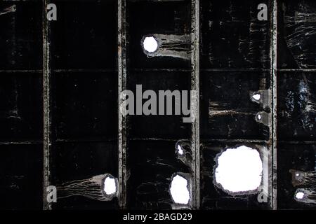 Dunkle Grunge Hintergrund alte holey gerippte Platten Stockfoto