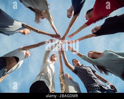 Befreundete Freunde schließen sich als Zeichen des gemeinsamen Geschäftes an. Das Konzept von Team und Community. Stockfoto
