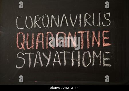 Quarantäne der Beschriftung bleiben Sie zu Hause. Warnung vor Ausbruch. Weiße Kreide auf Tafel im Zusammenhang mit der Epidemie von Coronavirus weltweit geschrieben. Bund 1 Stockfoto
