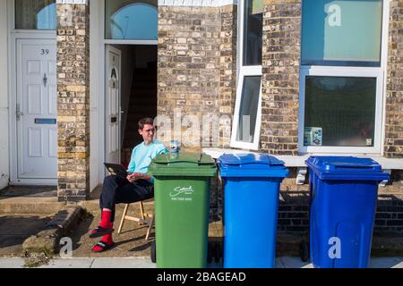 London UK 27. März 2020 EIN Mann sitzt neben seinem Haus in der Nähe von Burges Park South London während der COVID-19-Sperre. Stockfoto