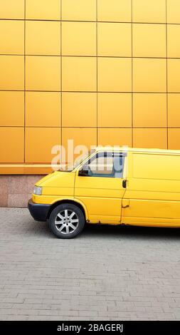 Ukraine, Kiew - 27. März 2020: Gelber Transporter in Gelb auf dem Hintergrund eines gelben Gebäudes Stockfoto