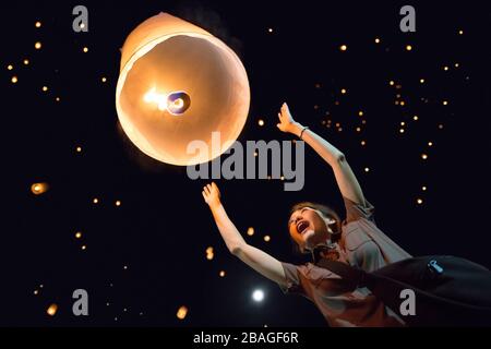 Chiang Mai, Thailand; 11. November 2016: Ein Mädchen mit Licht schwebenden Laternen aus Papier in Loi Krathong Stockfoto