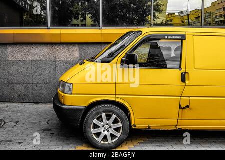 Ukraine, Kiew - 27. März 2020: Gelber Transporter in Gelb auf dem Hintergrund eines gelben Gebäudes Stockfoto
