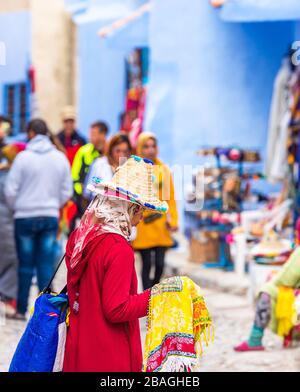 Chefchaouen, Marokko - 4. November 2019: Frau in einem Hut auf einer Stadtstraße Stockfoto