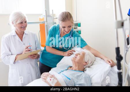 Leitender Patient mit Arzt und Krankenschwester im Krankenhaus Stockfoto
