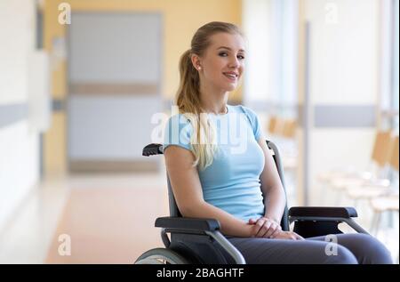 Porträt der jungen Frau, die im Rollstuhl sitzt Stockfoto