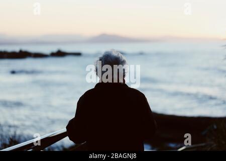 Ältere Frau mit Blick auf den Ozean. Stockfoto