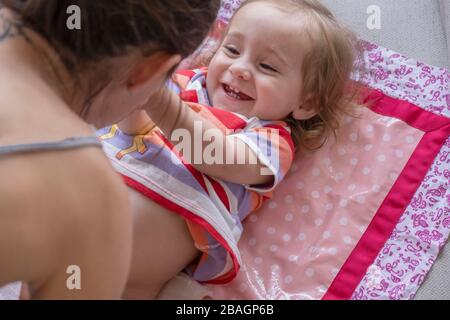 Mutter Wickelwechsel für ihr nettes Baby Mädchen. Stockfoto