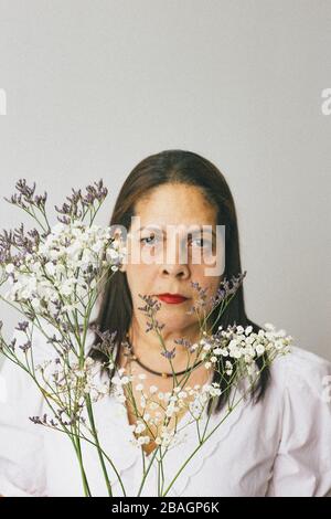 Hispanische Frau hält Baby Atem Blume Stockfoto