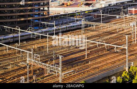 Viele Bahngleise in der Nähe des Bahnhofs Osaka von oben mit Schnellzug am Bahnsteig. Stockfoto