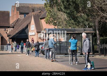 Reigate, Surrey, Großbritannien - 28. März 2020 - Einkäufer, die außerhalb des Supermarktes von Morrisons Schlange stehen, halten soziale Distanzierung aufrecht, um die Ausbreitung von Coronoviren zu stoppen Stockfoto