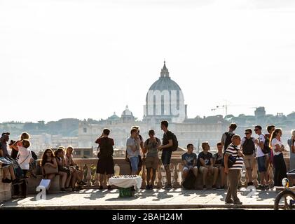 Touristen im Borghese Park mit Blick auf Rom und der Petersbasilika in der Ferne. Stockfoto