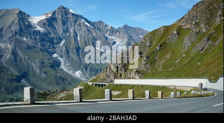 Fahren Sie auf der Großglockner Hochalpenstraße nach Norden. In der Ferne fahren mehrere Motorradfahrer gern auf der windigen Straße Stockfoto