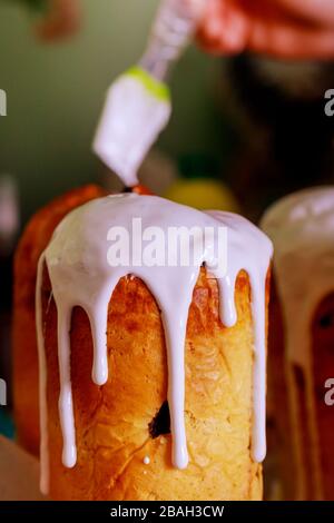 Mädchen in den Händen fügen dem osterkuchen Creme hinzu Stockfoto