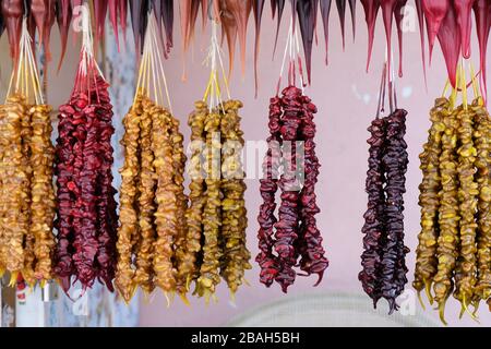 Churchkhela mit Walnüssen rot, gelb und braun hängend an einem Thread auf dem Zähler. Traditionelle Spezialitäten in Georgien. Lecker und gesund Georgischen desse Stockfoto