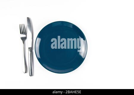 Blaue leere Platte mit Gabel und Messer isoliert auf weißem Hintergrund Stockfoto