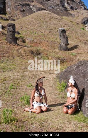 Rapa Nui Frauen in traditioneller Tracht sitzen im Rano Raraku Moai Steinbruch auf der Osterinsel Stockfoto