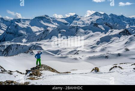 Man, Skitourer blickt auf schneebedeckte Bergketten, Skitour, Bergpanorama, Blick vom Geierjoch auf die Olperer und Zillertaler Alpen Stockfoto