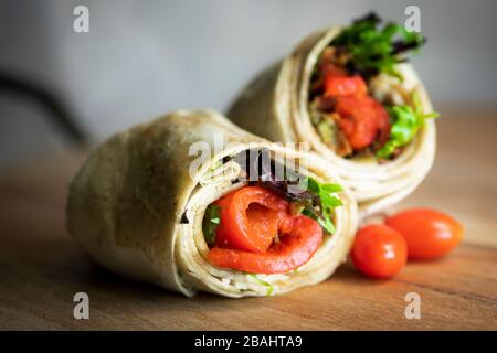 Ein frischer, schmackhafter gerösteter roter Pfeffer und eine putenverpackung auf einem Holzschnittbrett Stockfoto