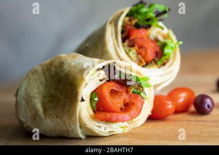 Ein frischer, schmackhafter gerösteter roter Pfeffer und eine putenverpackung auf einem Holzschnittbrett Stockfoto