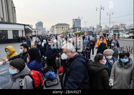 Kiew, Ukraine. März 2020. Russische Bürger, die Gesichtsmasken als Vorsichtsmaßnahme gegen die Ausbreitung von Coronavirus tragen, warten in einer Warteschlange auf die medizinische Kontrolle am Hauptbahnhof, bevor sie den Sonderzug nach Moskau einsteigen. Die Ukraine startet heute einen Zug zur Evakuierung ihrer Bürger aus Russland aufgrund der Coronavirus-Pandemie. Der Zug wird auch die Russen herausfahren, die die Ukraine vor dem Schließen der ukrainischen Grenzen verlassen wollten. Credit: SOPA Images Limited/Alamy Live News Stockfoto