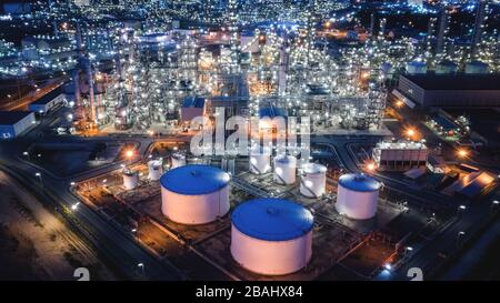 Große Industriegebiete der Öl- und Gasraffinerie, Luftbild von Industrieanlagen, Öllagertanks und Pipeline in der Nacht Stockfoto