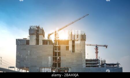 Panoramaansicht bei den Arbeitern auf großen Baustellen und viele Kräne arbeiten im Industrieneubaugeschäft. Stockfoto