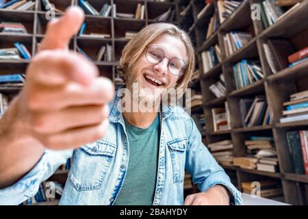 Junge bärtige lächelnde Studenten Blogger schauen auf die Kamera. Stockfoto