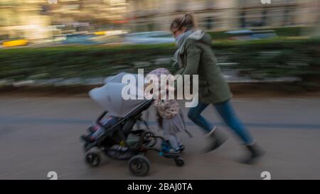 Die Mutter auf der Flucht mit einem Kinderwagen in Barcelona Spanien Stockfoto