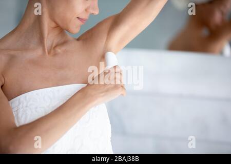 Frau wendet Antitranspirant an, nachdem sie im Nahbild am Morgen geduschen war Stockfoto