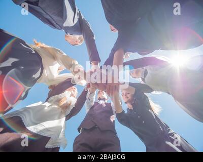 Highschool-Schüler schließen sich mit einem Zeichen starker Freundschaft und Graduierung an. Stockfoto