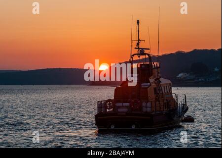 Courtmacsherry, West Cork, Irland. März 2020. Die Sonne geht am ersten vollen Tag der landesweiten Sperrung aufgrund der Covid-19-Pandemie hinter dem Rettungsboot von Courtmacsherry auf. Quelle: AG News/Alamy Live News Stockfoto