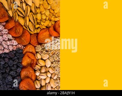 Verschiedene Nüsse und Trockenfrüchte, Aprikosen, Rosinen, Sesam in runder Form auf Betongrund, Zink, Eisen, Magnesium, Mangan, phosphorreiche Lebensmittel Stockfoto