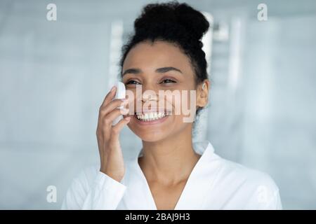 Afrikanerin reinigt Gesicht mit supersanftem Gesichtsschwamm Stockfoto