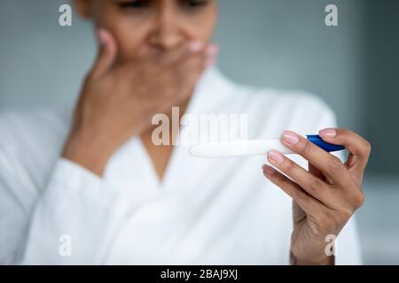 Nahaufnahme afrikanischer weiblicher Hand mit Schwangerschaftstest Stockfoto