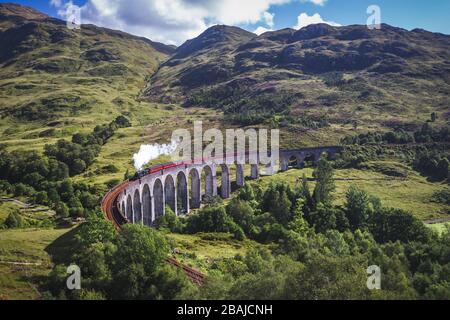 Glenfinnan Railway Viaduct in Schottland mit der Jacobite Dampfeisenbahn, die überfahren wird. Stockfoto