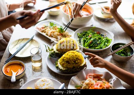 Leute, die im Restaurant ein großes thailändisches Essen essen Stockfoto