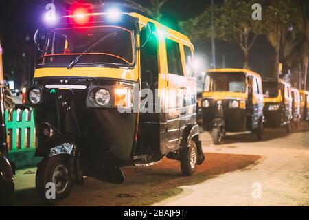 Goa, Indien. Auto Rickshaw oder Tuk-Tuk parkt auf der Straße für die Miete in Nachtilluminationen. Stockfoto