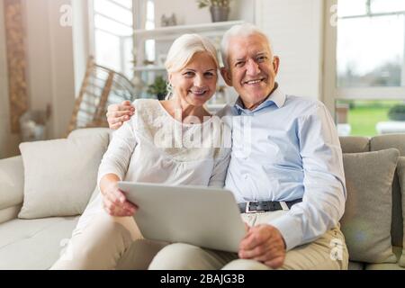 Glückliches älteres Paar, das sich in ihrem Haus erholt Stockfoto